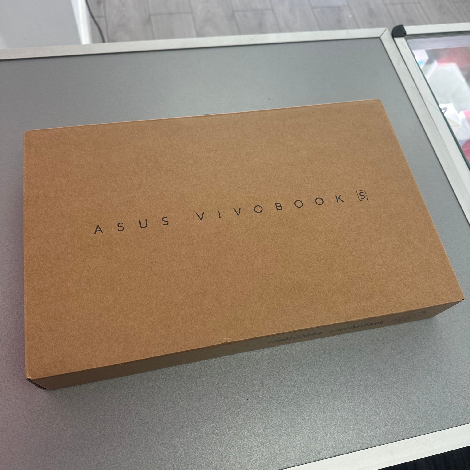 Brown box with 'ASUS VIVOBOOK' branding on a gray surface