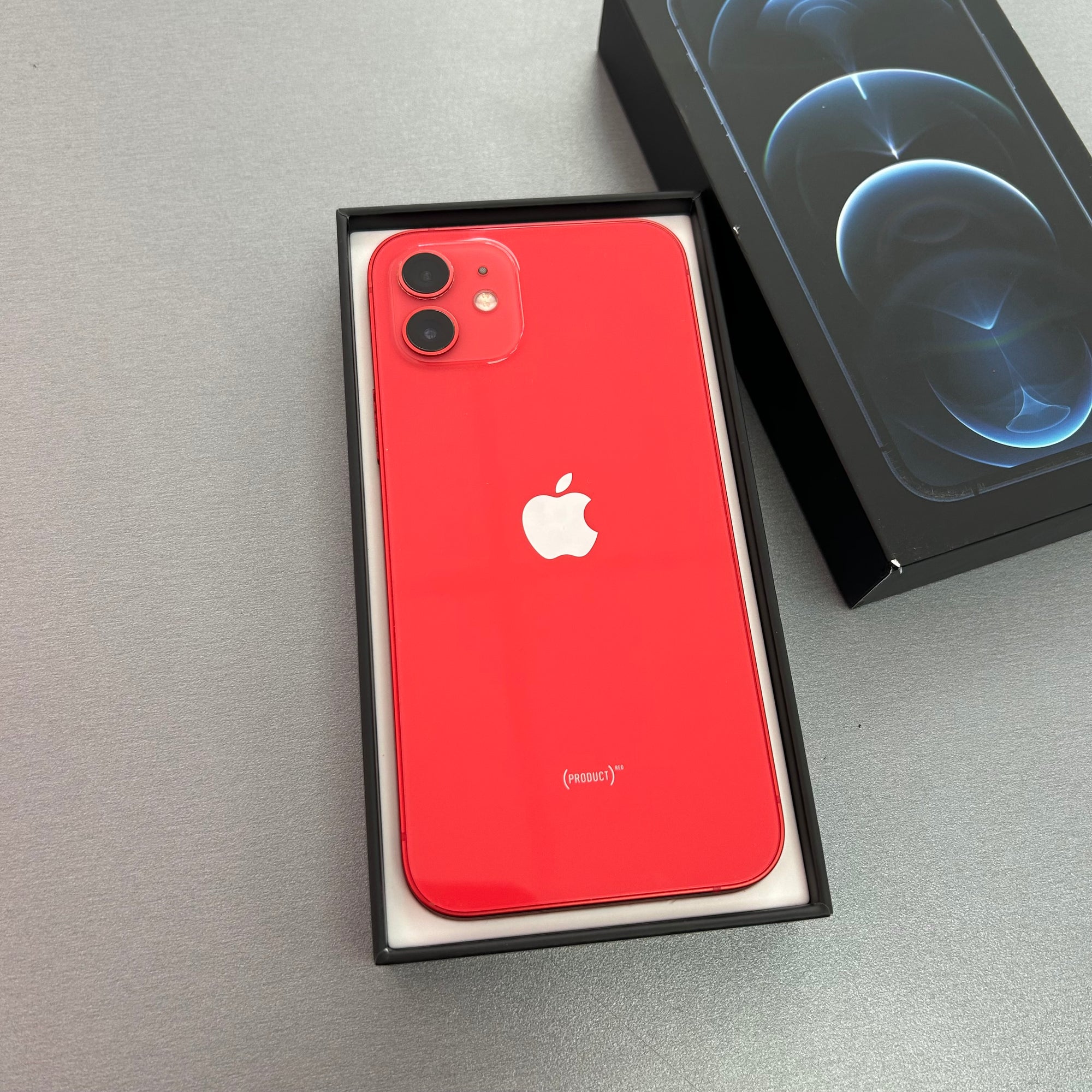 Red iPhone in a box on a gray surface