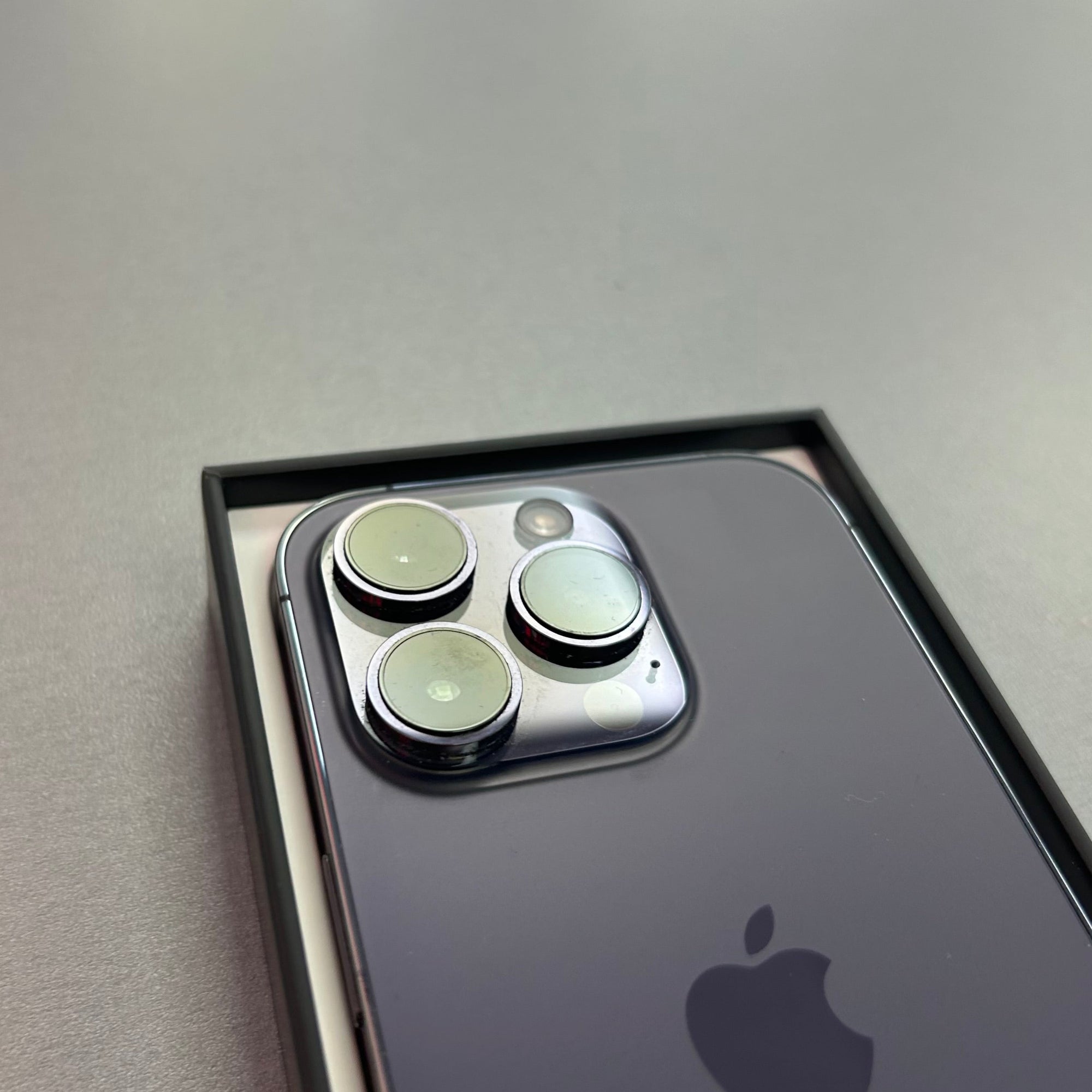 Apple iPhone 14 Pro - Purple 128GB with 100% Battery Health Smartphone with Apple logo on a gray background