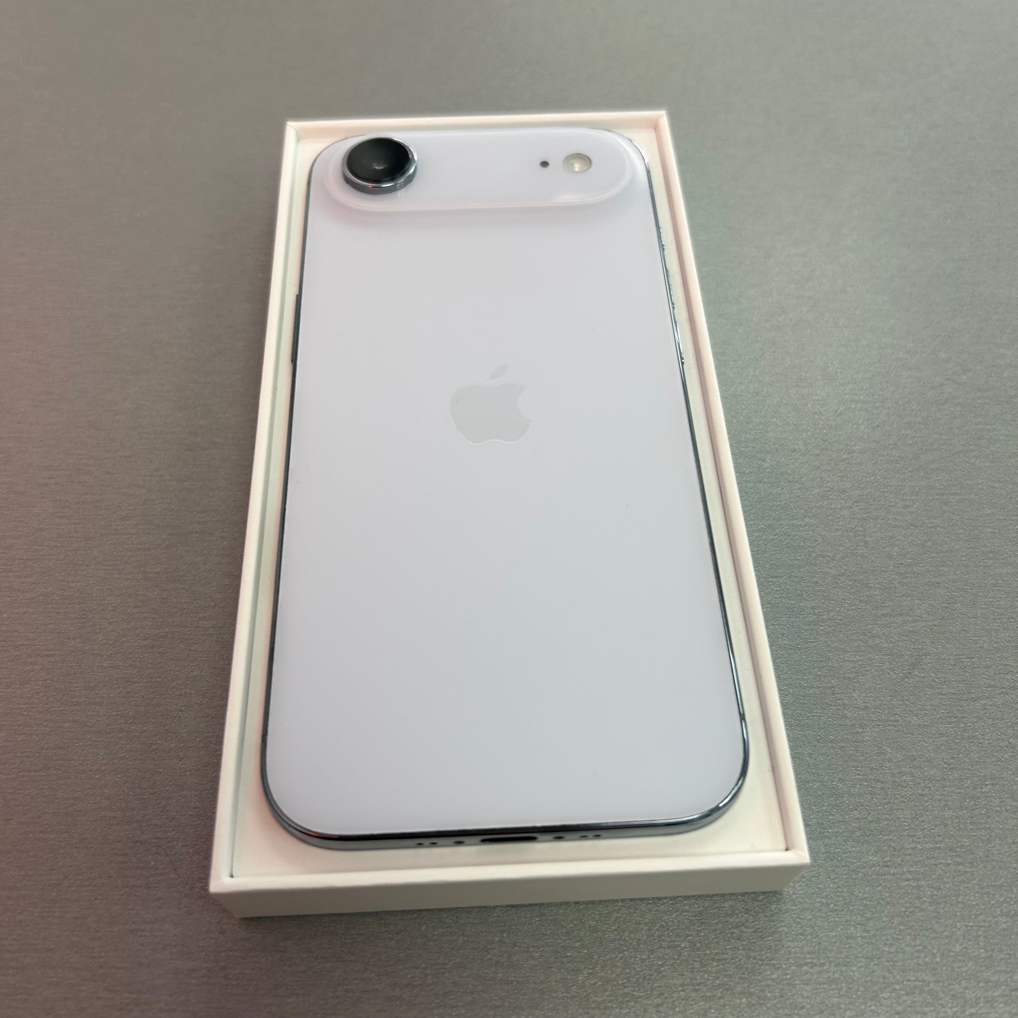 sky blue iphone air smartphone in a box on a gray surface