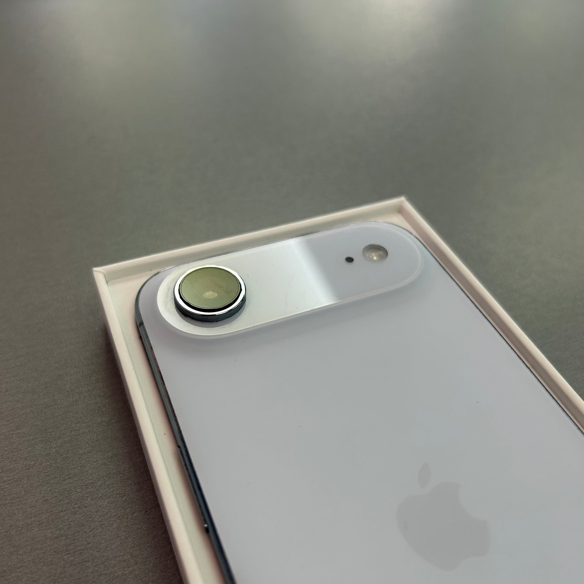 Close-up of an Apple smartphone with a focus on the camera and logo.
