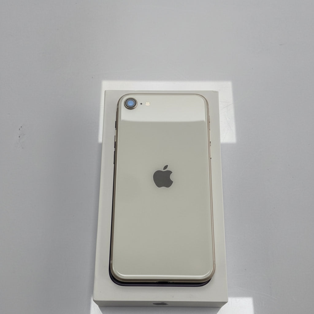 An Apple iPhone SE 2022 in white color, displayed in front of its packaging box.