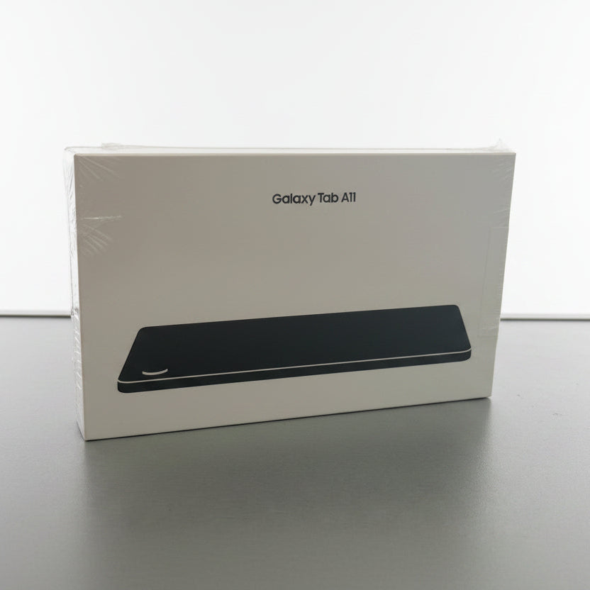 Samsung Galaxy Tab A11 retail box in white packaging with a black device illustration, sitting on a gray tabletop near a window.