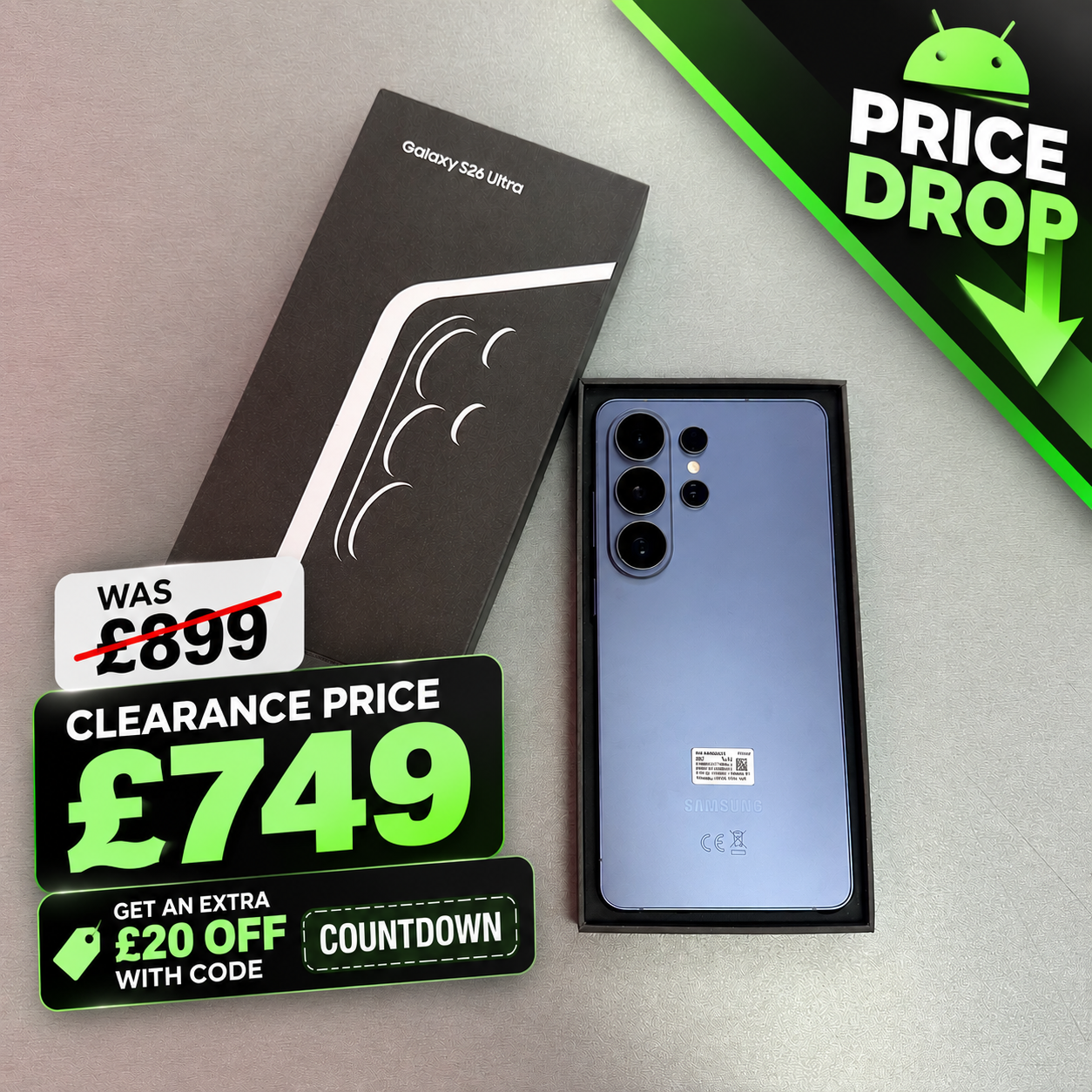 Samsung Galaxy S26 Ultra smartphone shown next to its black retail box on a gray surface, with promotional sale graphics including 'PRICE DROP', 'WAS £899', and 'CLEARANCE PRICE £749'.