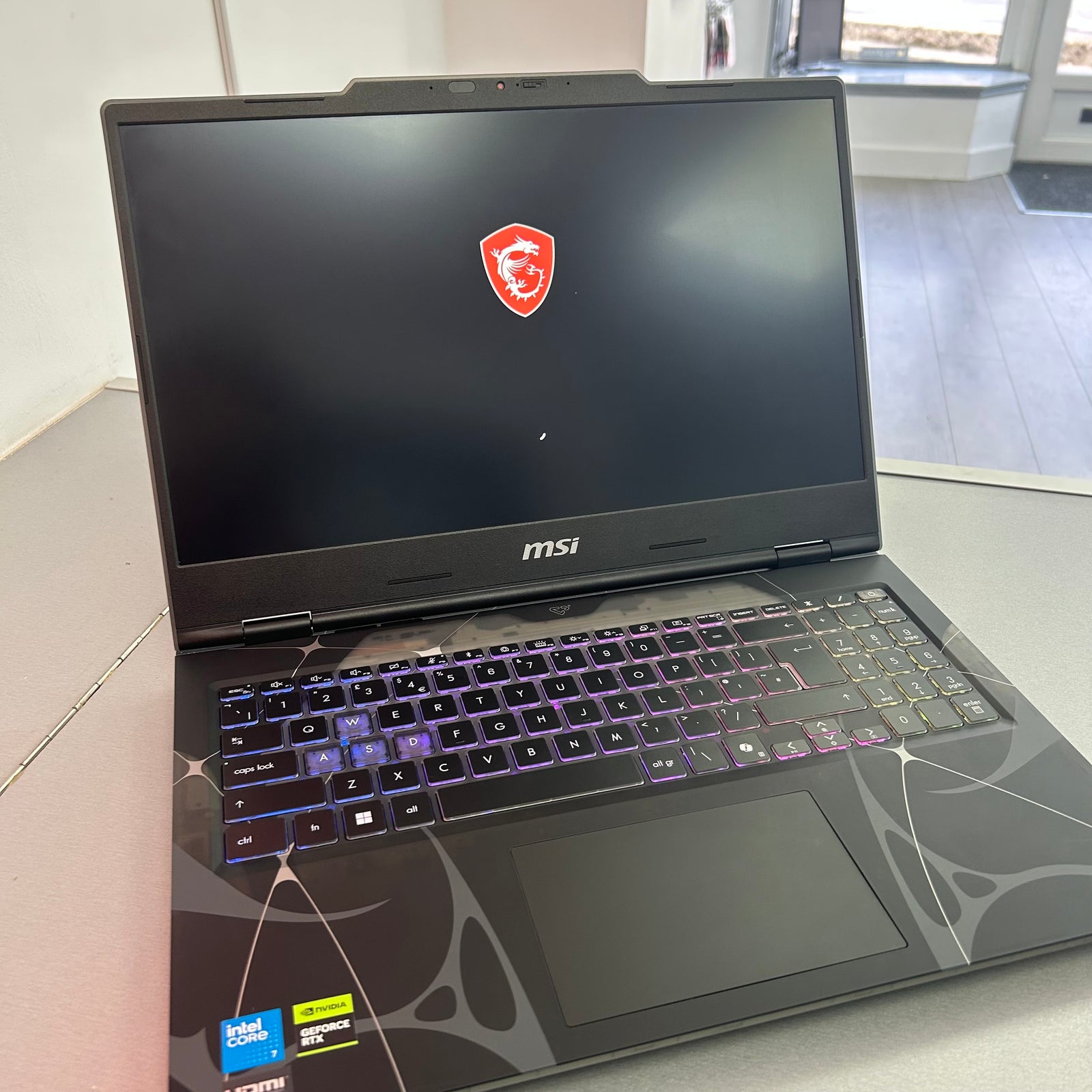 MSI laptop with a logo on the screen, placed on a surface.