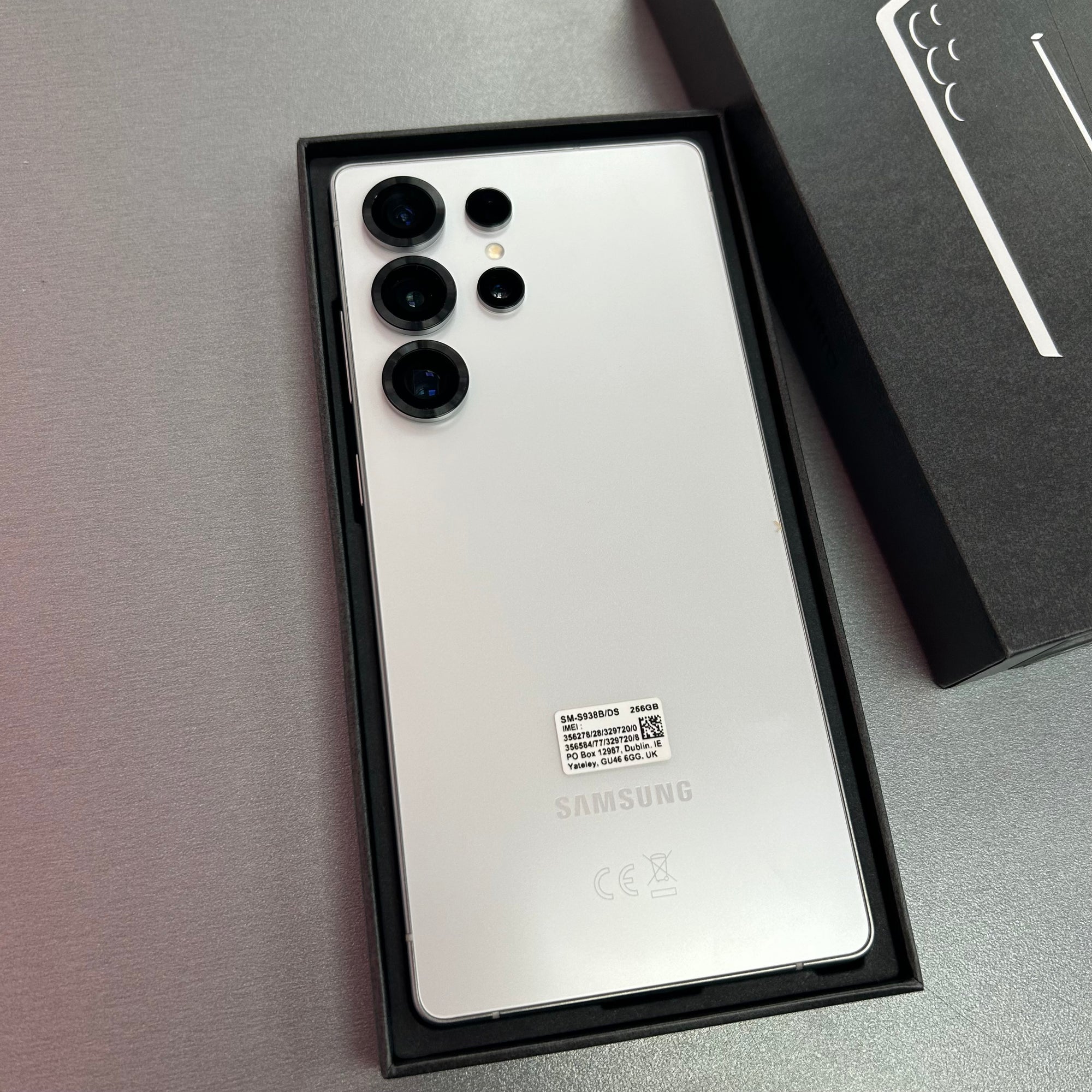 Samsung smartphone in open box on a gray surface