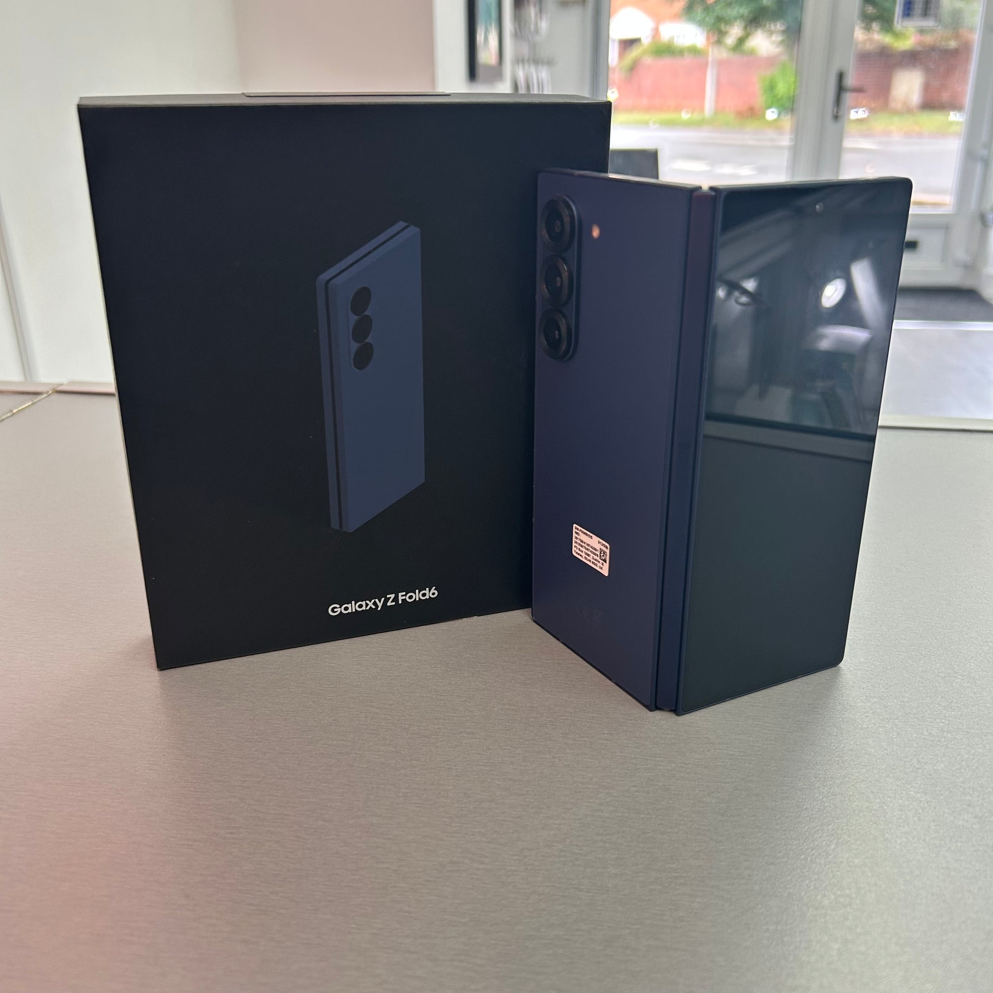 Samsung Galaxy Z Fold2 phone next to its packaging on a table