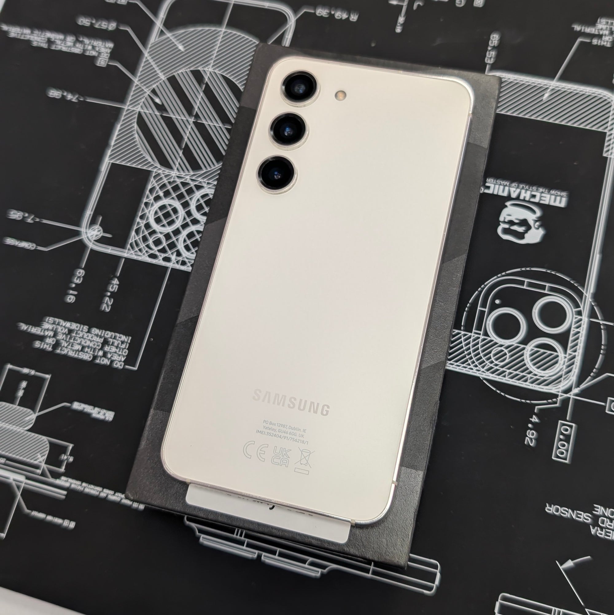 Samsung S23 smartphone with a protective case on a technical drawing background